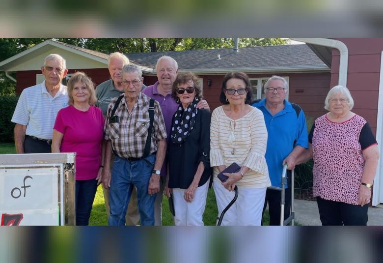 Class members stand outdoors, looking at the camera.
