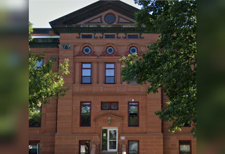 An exterior photo of the Plymouth County Iowa Courthouse in Le Mars, a multi-story, reddish brown brick building.