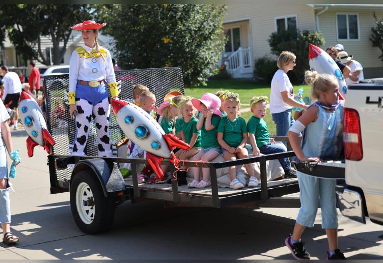 Casey Jacobs, Akron Children's Center director, and the members of this year's three-year-old preschool class, dress the part as the Toy Story class for their float in the homecoming parade.