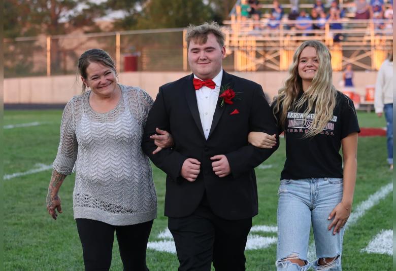 King candidate Karsen Herbert is announced during the football game, along with his family, Becky Hebert and Kaylee Hebert.